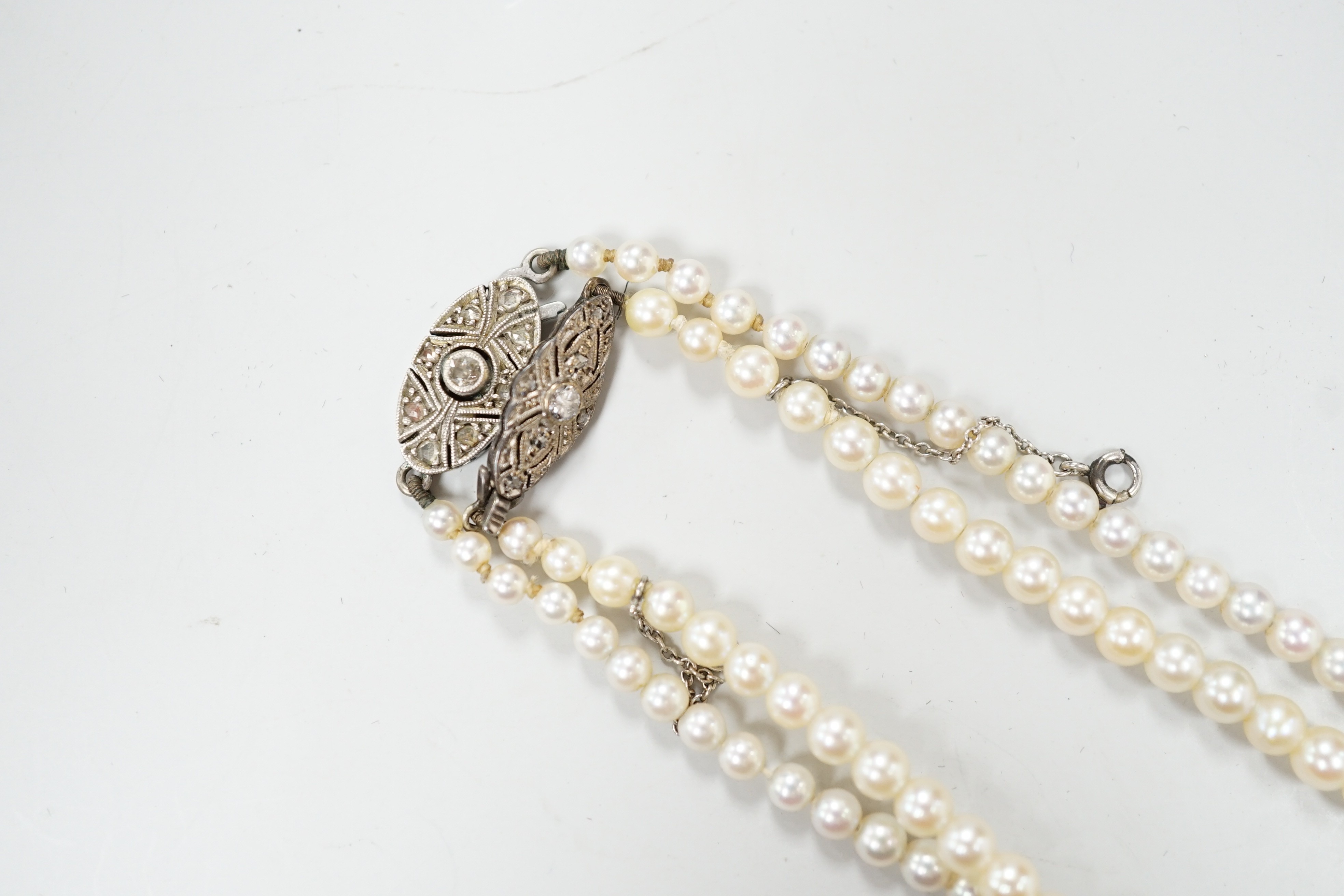 Two single strand graduated cultured pearl necklaces, both with diamond set white or yellow metal clasps, 39cm and 44cm.